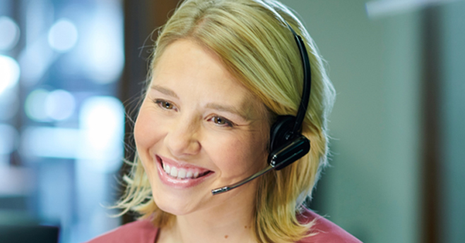 Transportation Service Rep for OTG smiling while on the phone with client